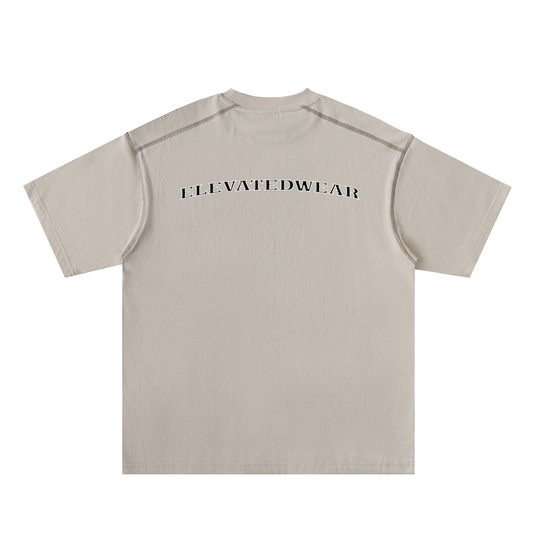 Beige t-shirt with 'ELEVATEDWEAR' text on a white background