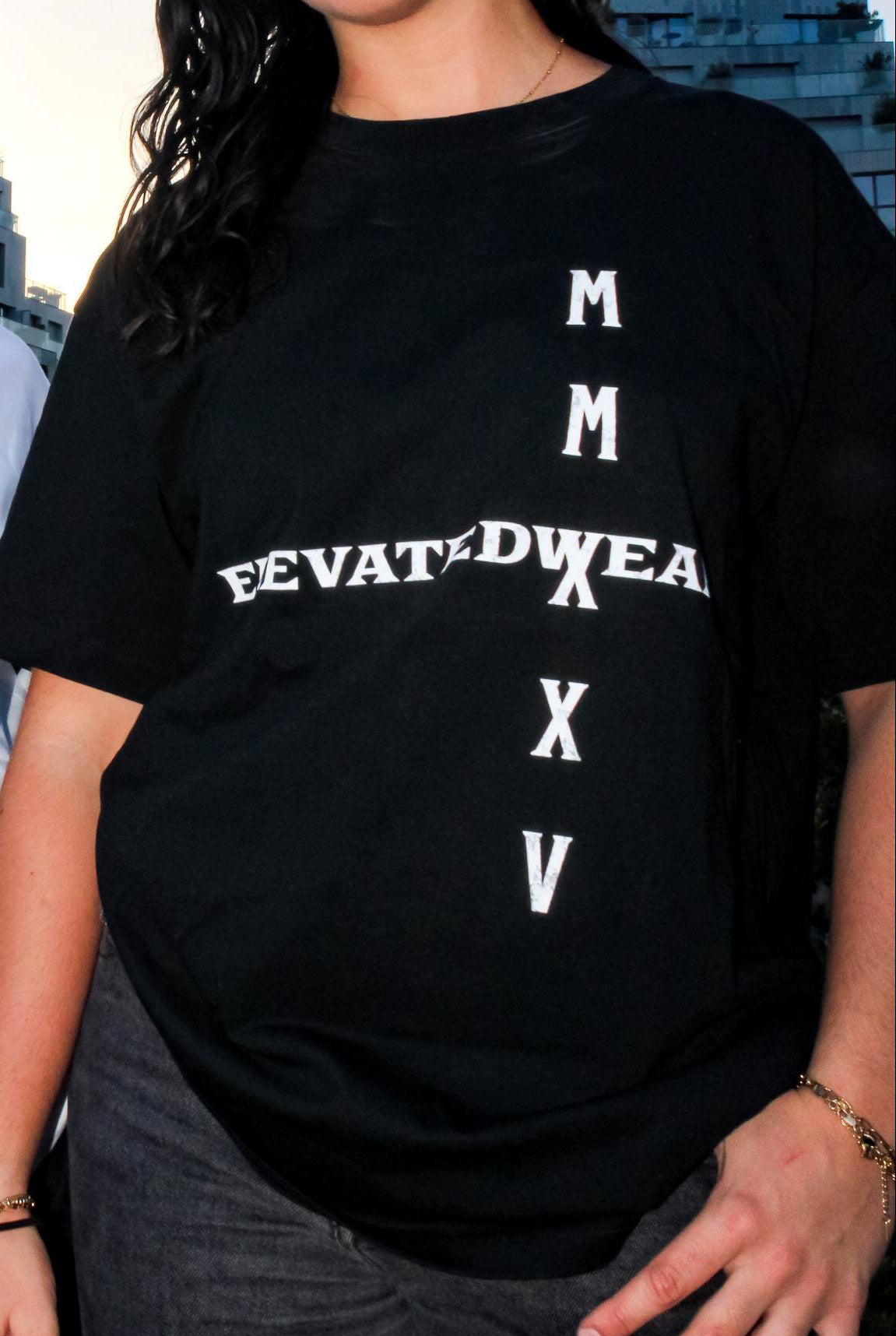 Two people wearing t-shirts with text designs against an urban background