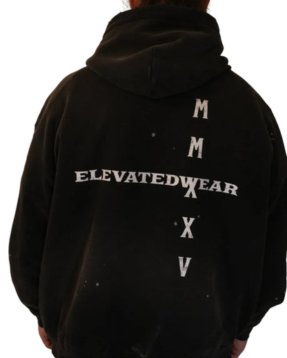 Person wearing a black hoodie with 'Elevatedwear' text on the back, standing against a plain background.