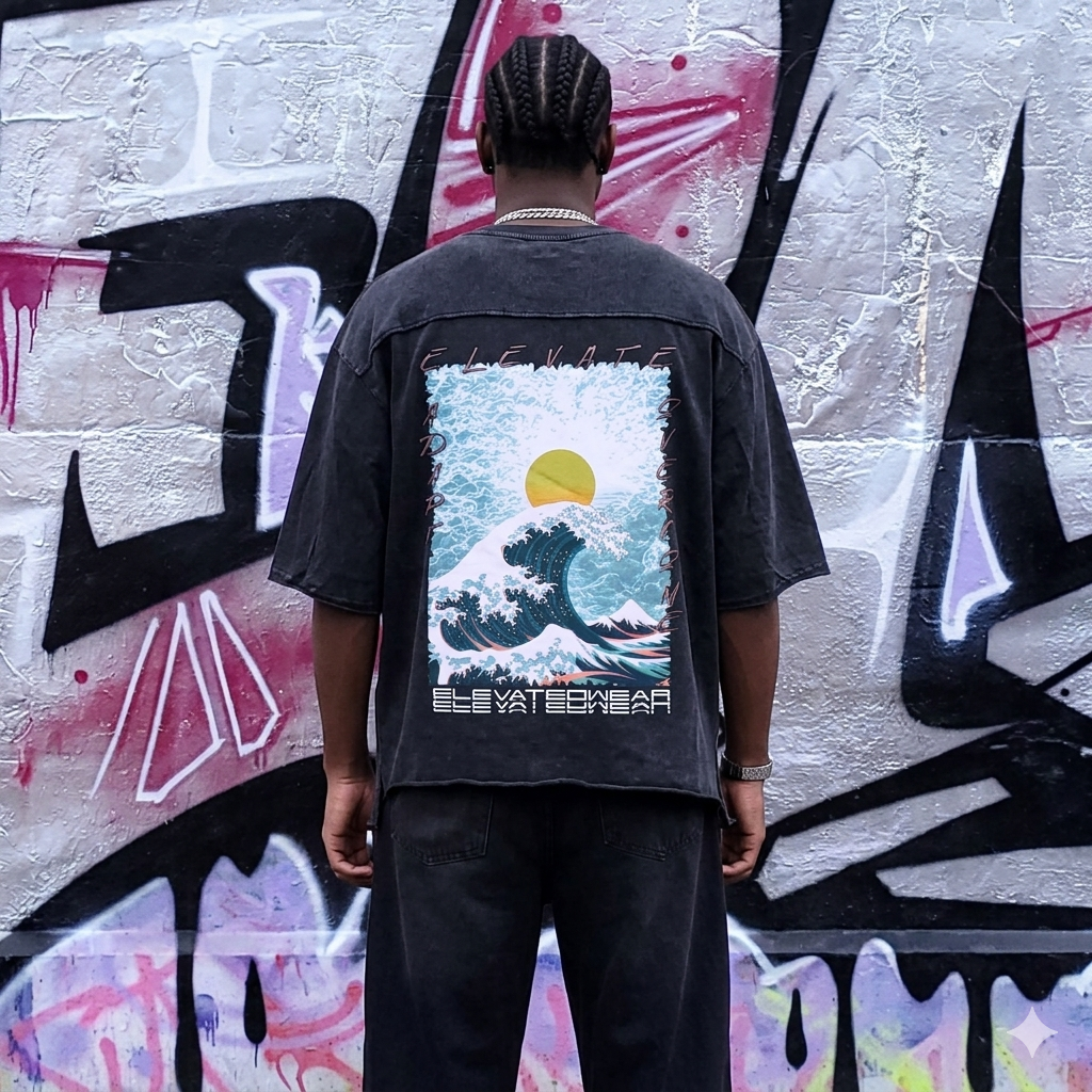 Person wearing a black shirt with a graphic design on the back, standing in front of a graffiti-covered wall.