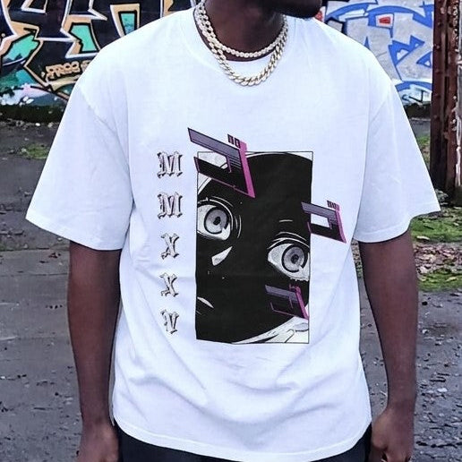 A man wearing a white oversized graphic t-shirt with a black and pink abstract face design and vertical Roman numerals, paired with gold chain necklaces, set against a graffiti-covered outdoor wall.