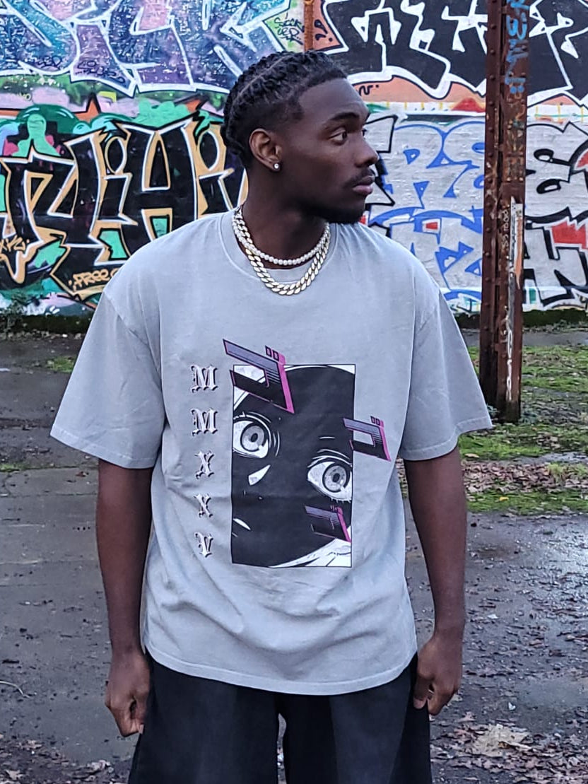 Person wearing a graphic t-shirt in front of a graffiti-covered wall