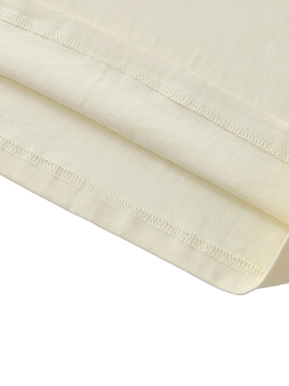 Close-up of a folded cream-colored fabric with visible stitching on a white background